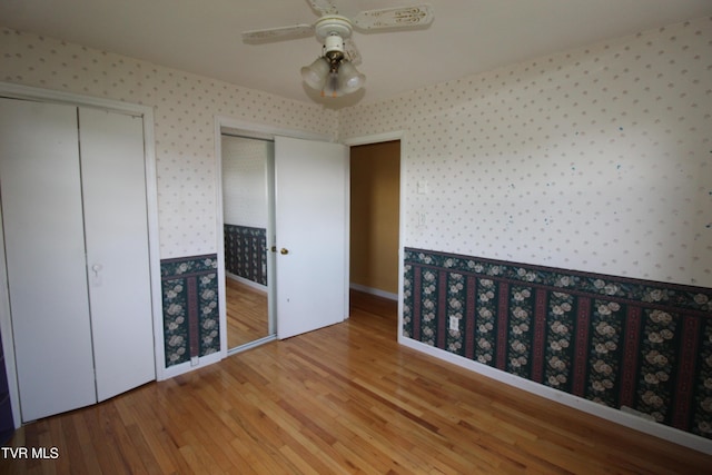 288 Hicks Rd, Piney Flats, TN 37686 - unfurnished bedroom with wallpapered walls, wood finished floors, two closets, and a ceiling fan
