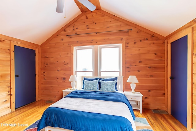 917 Pennsylvania Ave, Bristol, TN 37620 - bedroom featuring lofted ceiling, wooden walls, light wood finished floors, and a ceiling fan