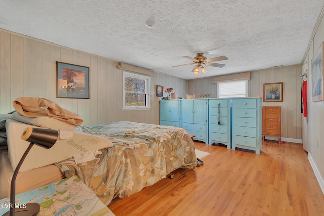 473 Oak Grove Rd, Gray, TN 37615 - bedroom with light wood-style floors, a textured ceiling, a ceiling fan, and wooden walls