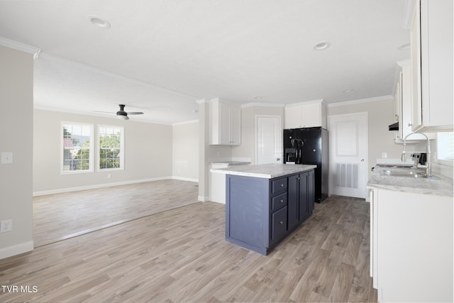 1024 Walnut Ave, Kingsport, TN 37660 - kitchen featuring black fridge, a center island, ornamental molding, white cabinetry, and light wood-type flooring