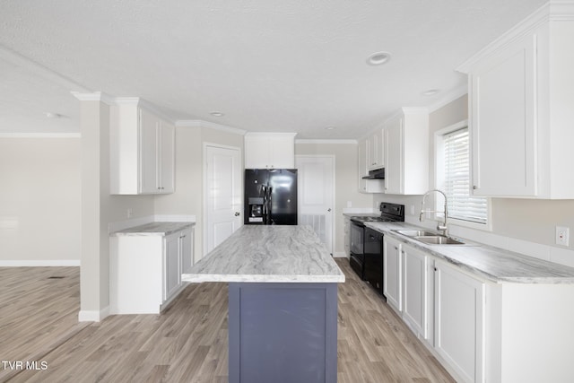 1024 Walnut Ave, Kingsport, TN 37660 - kitchen with black appliances, under cabinet range hood, light wood-type flooring, white cabinetry, and a center island