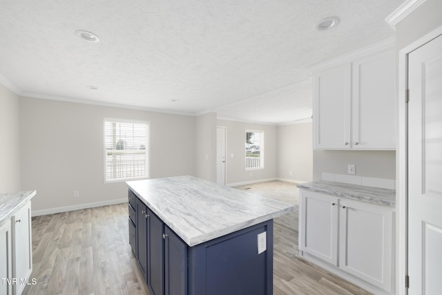 1024 Walnut Ave, Kingsport, TN 37660 - kitchen featuring light wood-style flooring, blue cabinetry, white cabinets, ornamental molding, and a textured ceiling