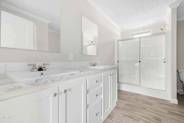 1024 Walnut Ave, Kingsport, TN 37660 - bathroom with crown molding, a stall shower, double vanity, wood finished floors, and a textured ceiling