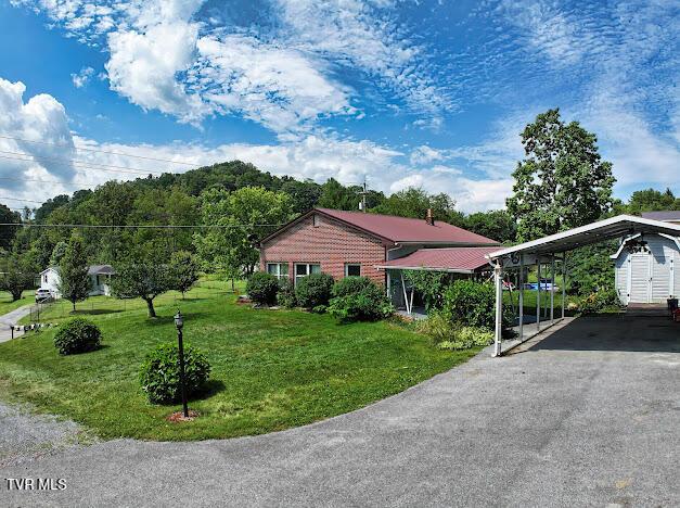 8087 Baptist Valley Rd, North Tazewell, VA 24630 - view of front of house featuring a carport, a front lawn, and asphalt driveway