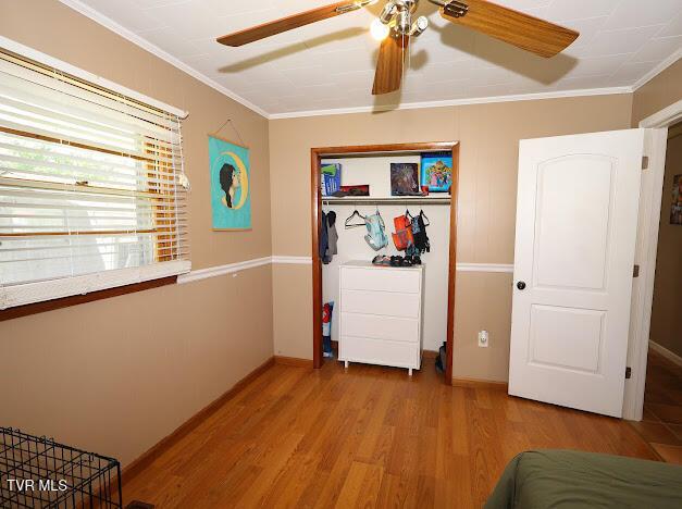 8087 Baptist Valley Rd, North Tazewell, VA 24630 - bedroom featuring wood finished floors, crown molding, a closet, and a ceiling fan