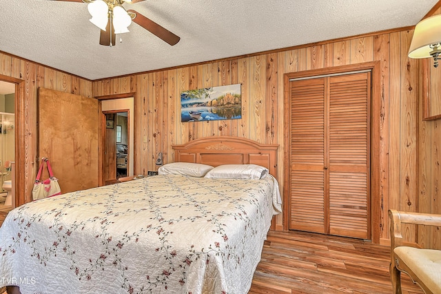 15813 Black Hollow Rd, Abingdon, VA 24210 - bedroom featuring wood walls, a textured ceiling, crown molding, wood finished floors, and a closet