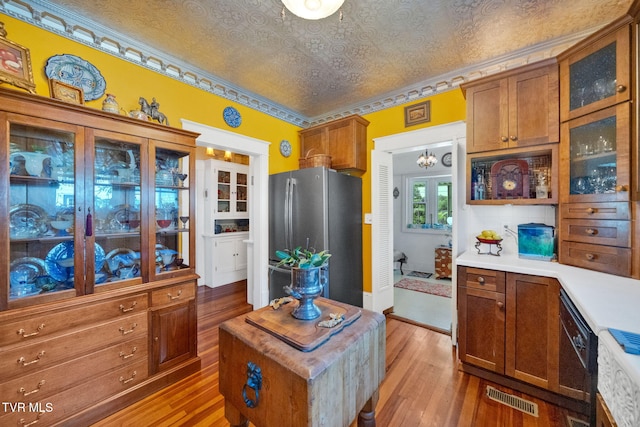 201 W Wanola Ave, Kingsport, TN 37660 - kitchen featuring freestanding refrigerator, light wood finished floors, brown cabinetry, light countertops, and a chandelier