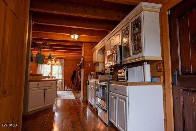 332 Undertaker Blvd, Clintwood, VA 24228 - kitchen featuring appliances with stainless steel finishes, beam ceiling, dark wood finished floors, a chandelier, and wood walls
