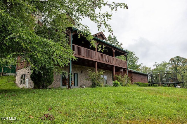 332 Undertaker Blvd, Clintwood, VA 24228 - back of property with stone siding, a lawn, a deck, and a trampoline