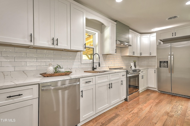 1091 Long Crescent Dr, Bristol, VA 24201 - kitchen with stainless steel appliances, white cabinets, light wood-type flooring, backsplash, and light stone countertops