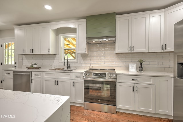 1091 Long Crescent Dr, Bristol, VA 24201 - kitchen with stainless steel appliances, wall chimney range hood, plenty of natural light, white cabinetry, and recessed lighting