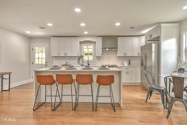 1091 Long Crescent Dr, Bristol, VA 24201 - kitchen with stainless steel fridge with ice dispenser, wall chimney exhaust hood, a kitchen bar, a center island, and recessed lighting