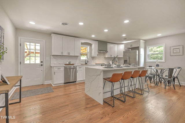 1091 Long Crescent Dr, Bristol, VA 24201 - kitchen with stainless steel appliances, a kitchen bar, light wood-style flooring, backsplash, and recessed lighting