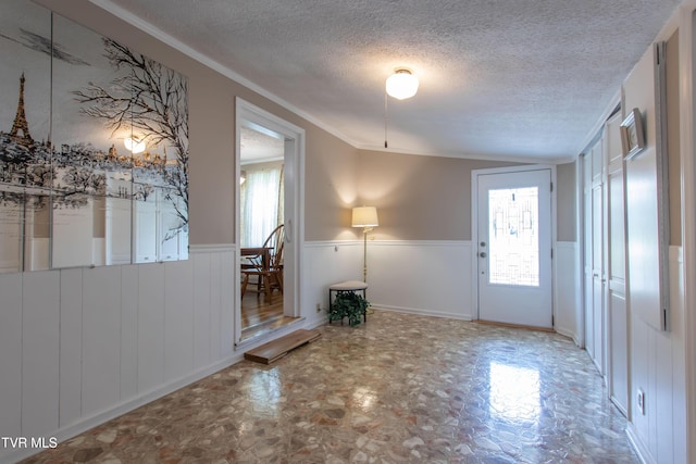 184 Center St, Bristol, VA 24201 - foyer with lofted ceiling, plenty of natural light, wainscoting, and a textured ceiling