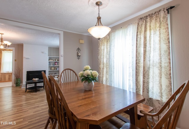 184 Center St, Bristol, VA 24201 - dining space with a textured ceiling, light wood finished floors, a chandelier, and a fireplace