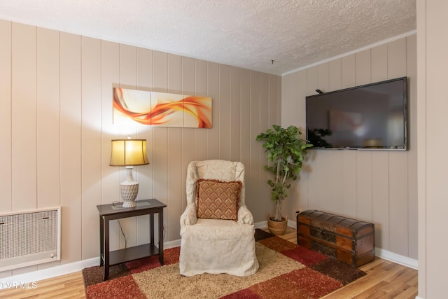 184 Center St, Bristol, VA 24201 - sitting room featuring wood finished floors, a textured ceiling, heating unit, and crown molding