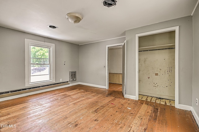 301 Keenburg Rd, Bluff City, TN 37618 - unfurnished bedroom with baseboard heating, wood-type flooring, a closet, and heating unit