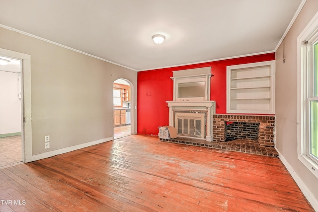 301 Keenburg Rd, Bluff City, TN 37618 - unfurnished living room with a brick fireplace, hardwood / wood-style floors, arched walkways, ornamental molding, and built in features