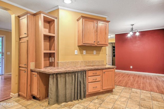 13275 Chip Ridge Rd, Abingdon, VA 24210 - kitchen with crown molding, arched walkways, light countertops, a textured ceiling, and hanging light fixtures