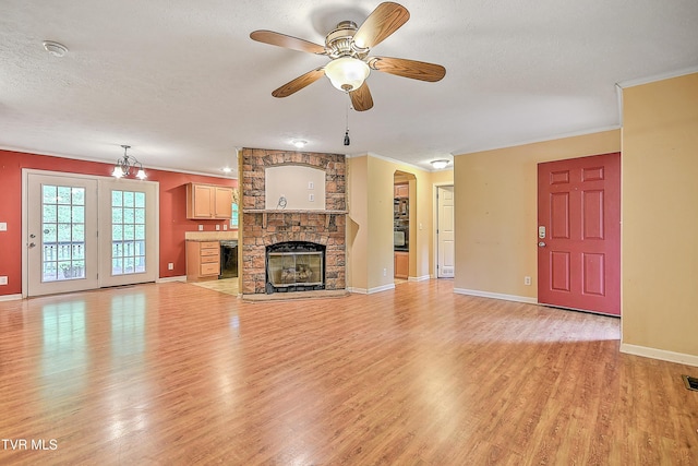 13275 Chip Ridge Rd, Abingdon, VA 24210 - unfurnished living room with light wood-style floors, a ceiling fan, ornamental molding, a fireplace, and a textured ceiling