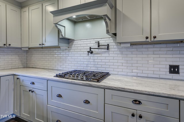 2 Longview Ln, Kingsport, TN 37660 - kitchen with black gas cooktop, backsplash, light stone counters, and exhaust hood