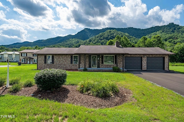 157 Spring St, Hampton, TN 37658 - ranch-style home featuring a mountain view, an attached garage, a front lawn, asphalt driveway, and brick siding