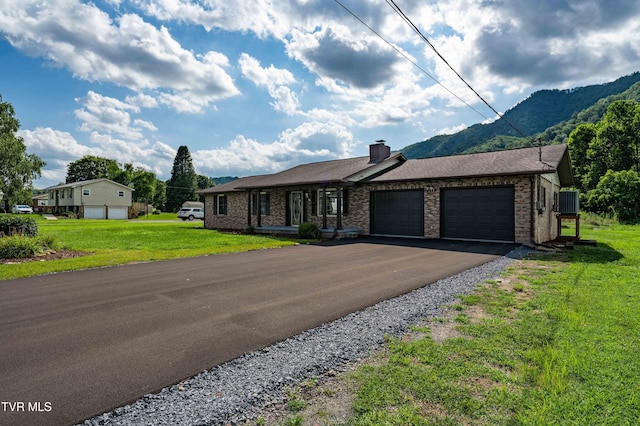 157 Spring St, Hampton, TN 37658 - ranch-style home featuring an attached garage, a front yard, asphalt driveway, a mountain view, and a chimney
