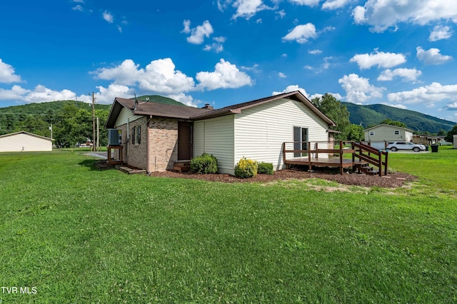 157 Spring St, Hampton, TN 37658 - view of side of home featuring a deck with mountain view, a yard, and brick siding