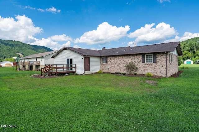 157 Spring St, Hampton, TN 37658 - back of property with a deck with mountain view, a lawn, and brick siding