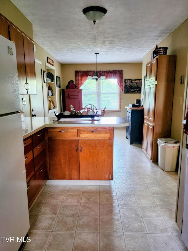 2020 Oakland St, Kingsport, TN 37660 - kitchen featuring freestanding refrigerator, a textured ceiling, light countertops, a peninsula, and a chandelier