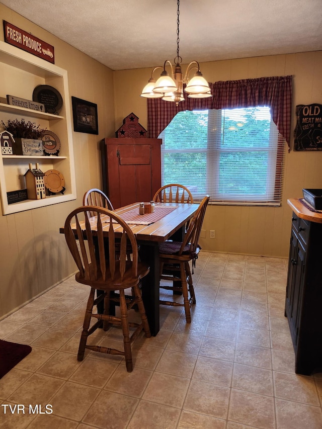 2020 Oakland St, Kingsport, TN 37660 - dining room with healthy amount of natural light, light tile patterned floors, a chandelier, wood walls, and a textured ceiling