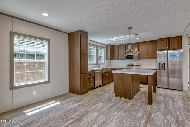 8492 Reedy Creek Rd, Bristol, VA 24202 - kitchen featuring stainless steel appliances, light countertops, light wood-style flooring, a kitchen island, and a textured ceiling