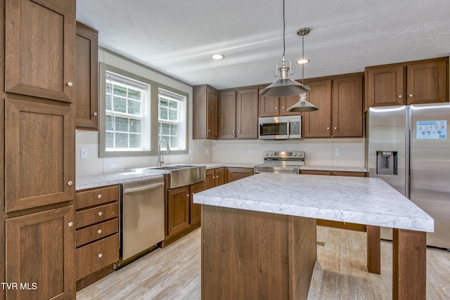 8492 Reedy Creek Rd, Bristol, VA 24202 - kitchen with appliances with stainless steel finishes, light wood-style flooring, light countertops, a center island, and hanging light fixtures
