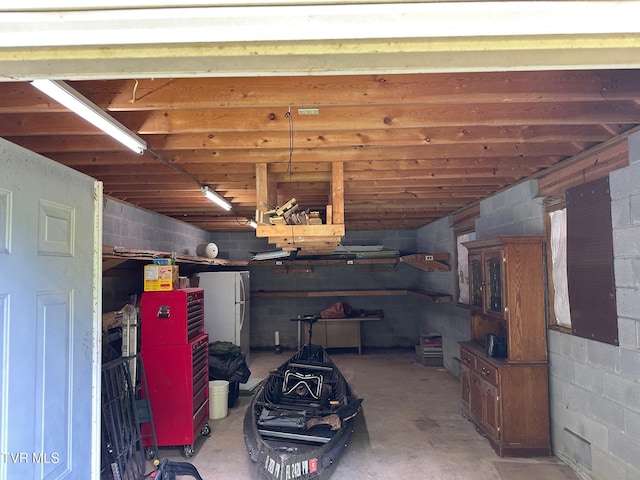 542 Sigman Hollow Rd, Bluff City, TN 37618 - garage with freestanding refrigerator and concrete block wall