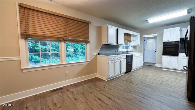 542 Sigman Hollow Rd, Bluff City, TN 37618 - kitchen featuring black appliances, white cabinetry, dark wood finished floors, a textured ceiling, and tasteful backsplash