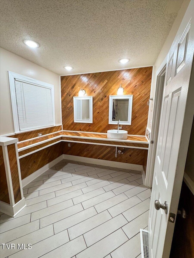 542 Sigman Hollow Rd, Bluff City, TN 37618 - bathroom featuring a textured ceiling, wooden walls, recessed lighting, and double vanity
