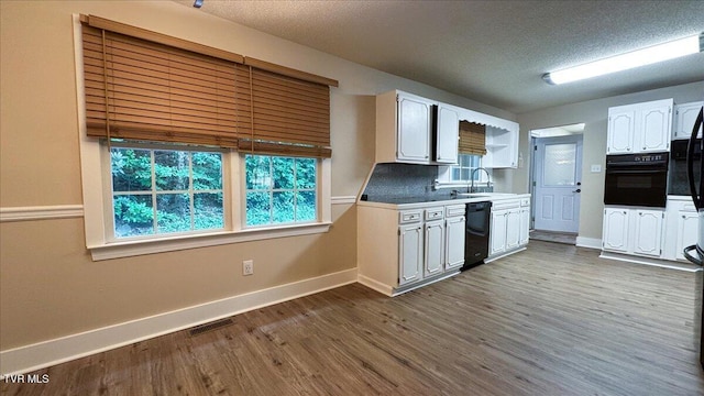 542 Sigman Hollow Rd, Bluff City, TN 37618 - kitchen with black appliances, white cabinets, dark wood-style flooring, a textured ceiling, and light countertops