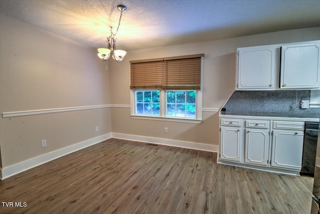 542 Sigman Hollow Rd, Bluff City, TN 37618 - unfurnished dining area with a chandelier, dark wood-style flooring, and a textured ceiling
