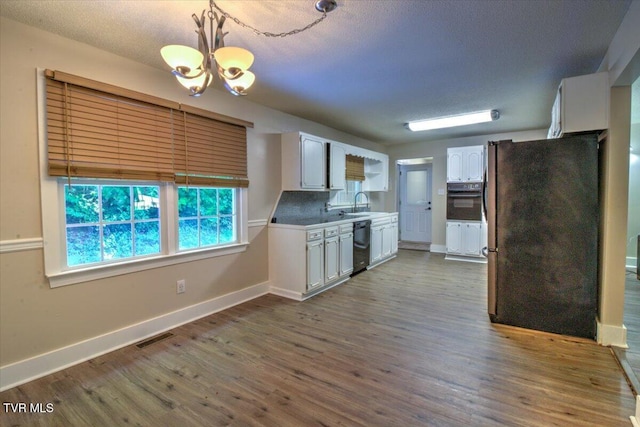 542 Sigman Hollow Rd, Bluff City, TN 37618 - kitchen featuring freestanding refrigerator, a chandelier, white cabinetry, oven, and dishwasher