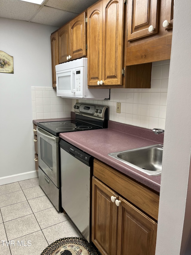 102 Baskins Creek Byp Unit 209, Gatlinburg, TN 37738 - kitchen featuring appliances with stainless steel finishes, tasteful backsplash, light tile patterned floors, dark countertops, and brown cabinetry