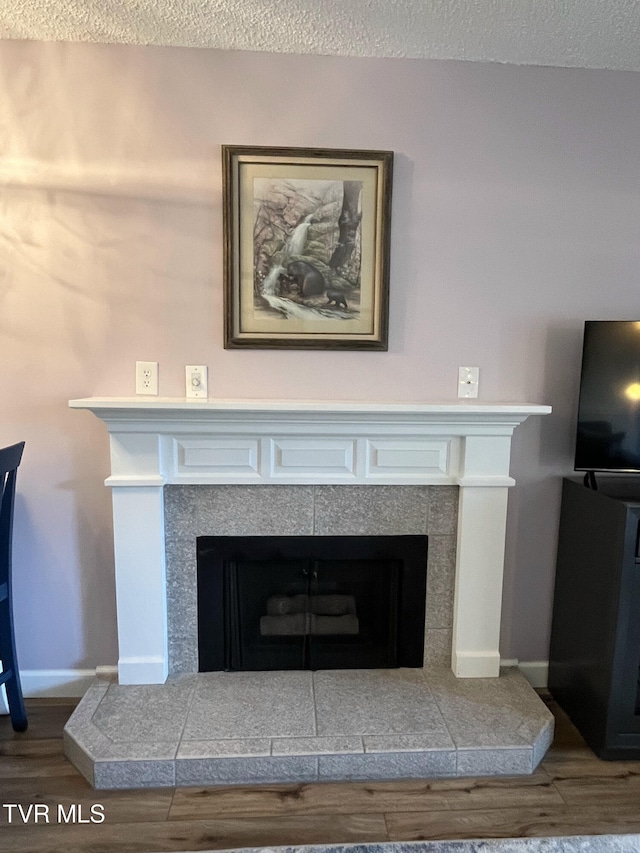 102 Baskins Creek Byp Unit 209, Gatlinburg, TN 37738 - detailed view of wood finished floors, a tiled fireplace, and a textured ceiling