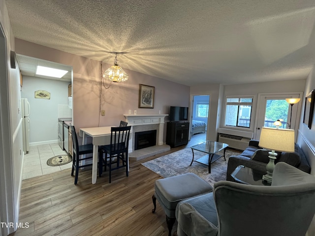 102 Baskins Creek Byp Unit 209, Gatlinburg, TN 37738 - living area featuring light wood-type flooring, a textured ceiling, a fireplace, and a wall mounted air conditioner