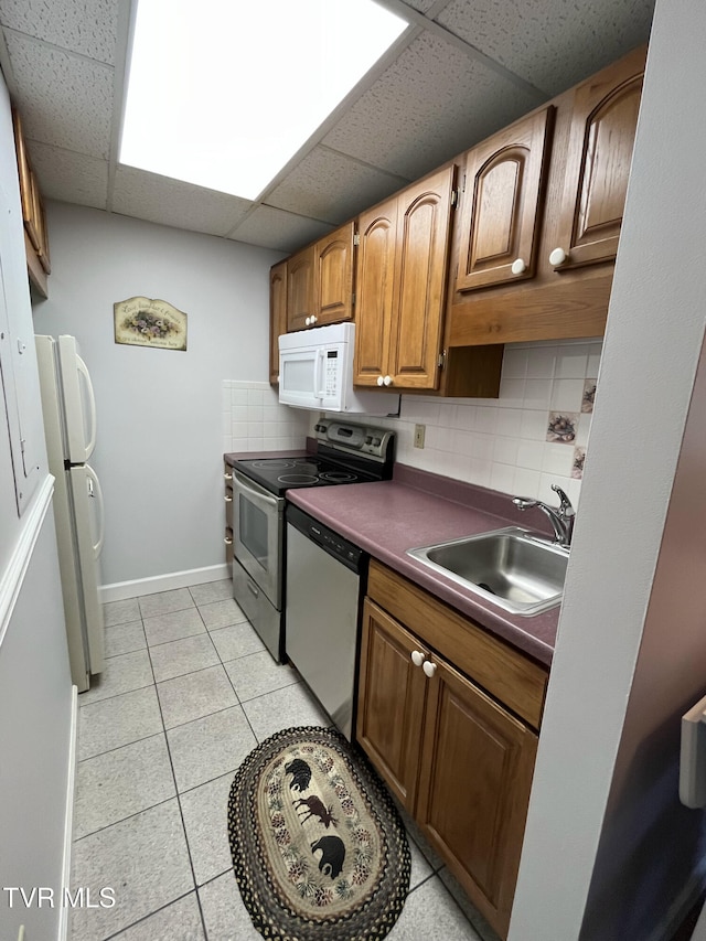 102 Baskins Creek Byp Unit 209, Gatlinburg, TN 37738 - kitchen with stainless steel appliances, a paneled ceiling, tasteful backsplash, light tile patterned floors, and dark countertops