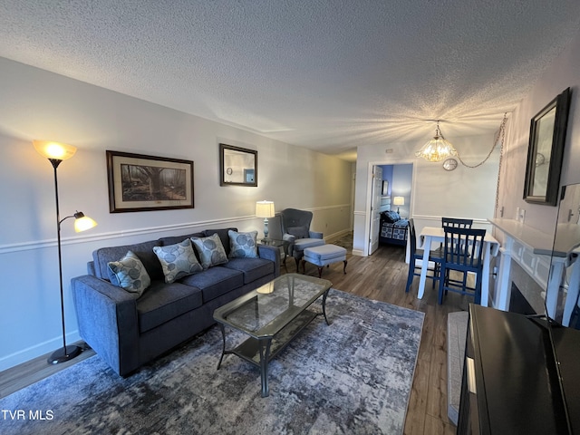 102 Baskins Creek Byp Unit 209, Gatlinburg, TN 37738 - living room featuring a textured ceiling, wood finished floors, and a chandelier