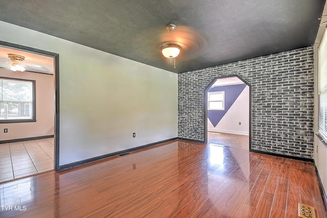 8822 Rich Valley Rd, Bristol, VA 24202 - empty room with a ceiling fan, arched walkways, wood finished floors, and brick wall