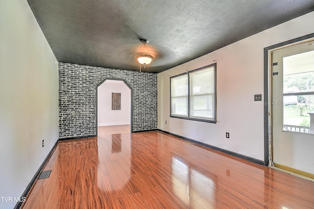 8822 Rich Valley Rd, Bristol, VA 24202 - spare room featuring wood finished floors, arched walkways, and a textured ceiling