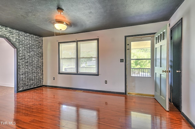 8822 Rich Valley Rd, Bristol, VA 24202 - empty room with wood finished floors, a textured ceiling, and arched walkways