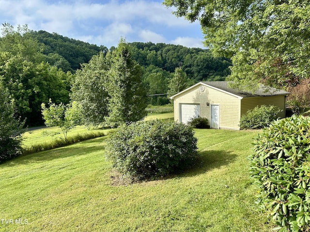 1277 Old Jonesboro Rd, Bristol, TN 37620 - view of grassy yard featuring an outdoor structure, a garage, and a view of trees
