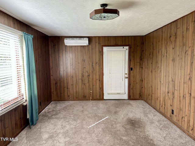 1277 Old Jonesboro Rd, Bristol, TN 37620 - empty room with a textured ceiling, a wall mounted AC, wood walls, and carpet flooring