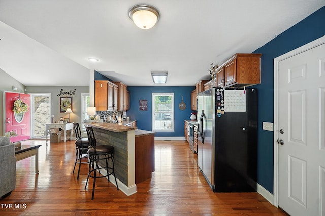 1014 Fox Meadow Cir, Bluff City, TN 37618 - kitchen with stainless steel fridge with ice dispenser, brown cabinetry, a breakfast bar area, and dark wood-style floors